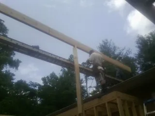 Carpenter setting a ridge beam over a new addition frame — Ice Dam Removal by Roofing Brothers in Belle Plaine