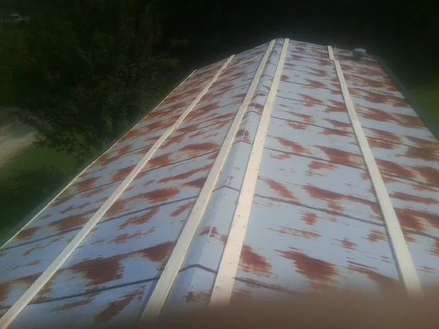 Rusted metal roof panels with new wood purlins before replacement — Storm Damage Roof Repair in Belle Plaine by Roofing Brothers