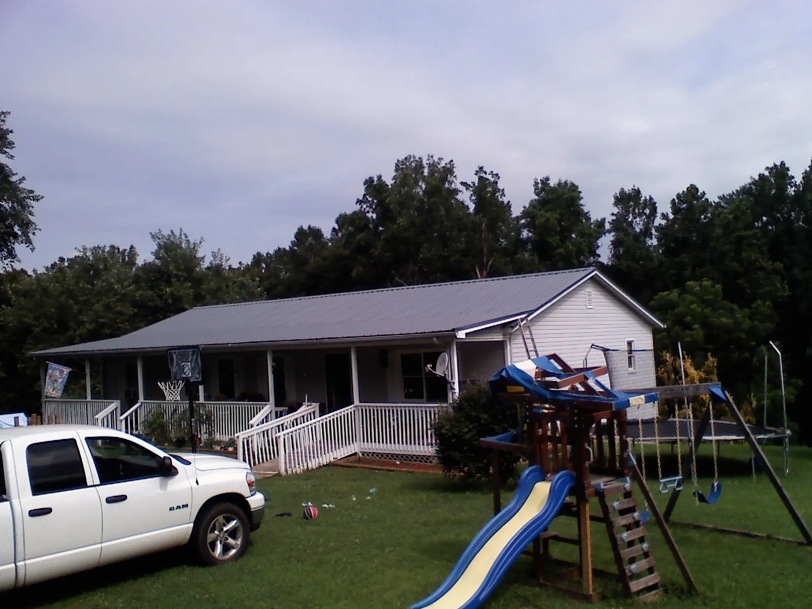Dark metal roof on a country home with a full length front porch in Belle Plaine