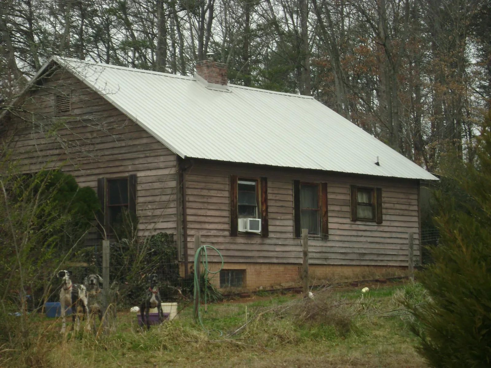 White metal roof on an old wood sided farmhouse, from a Metal Roof Installation job in Belle Plaine